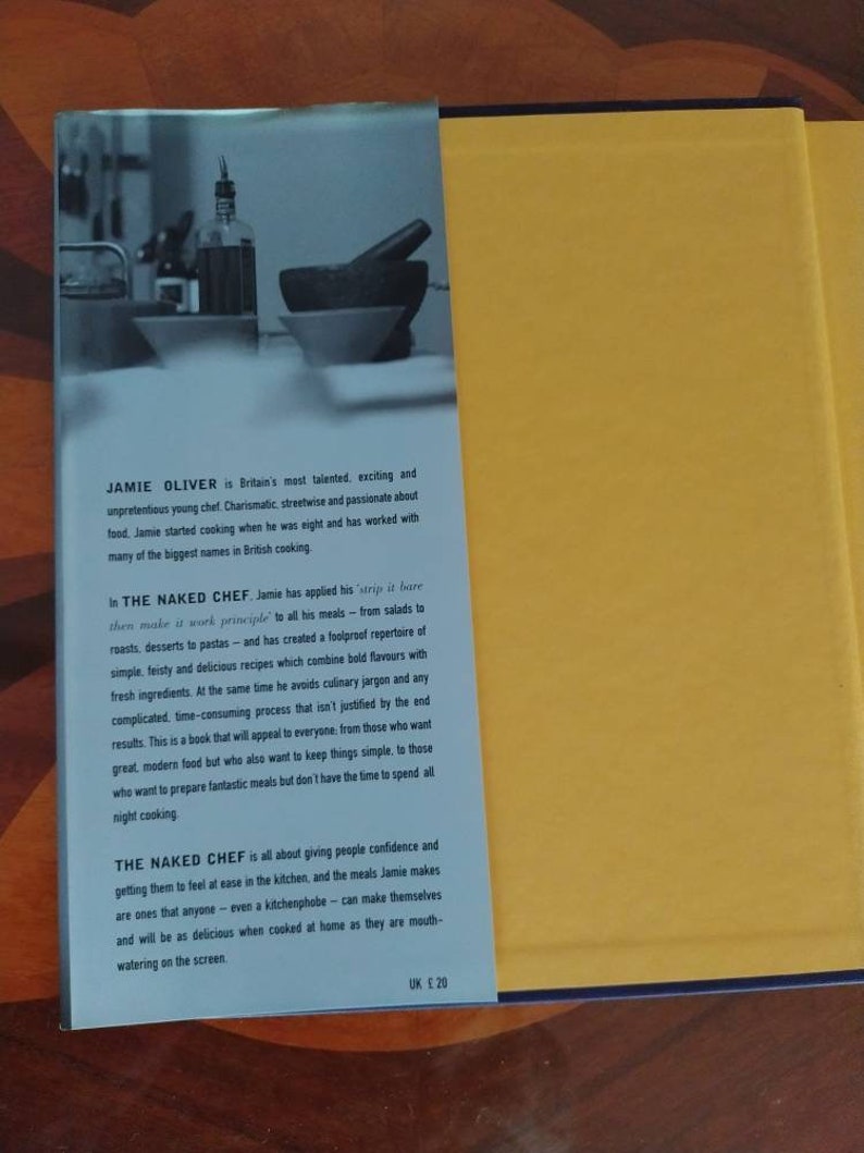Puede incluir: Una portada de libro con fondo amarillo y una imagen azul y blanca de un chef en la cocina. El t&iacute;tulo del libro es "The Naked Chef" y el autor es Jamie Oliver. El texto en la contraportada describe el libro como una gu&iacute;a de recetas simples y deliciosas que son f&aacute;ciles de hacer.