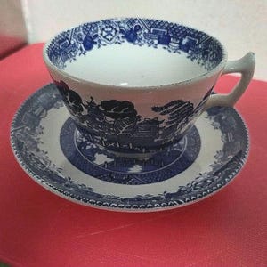May include: A blue and white porcelain teacup and saucer set with a floral pattern. The cup and saucer feature a traditional blue and white design with a floral motif.