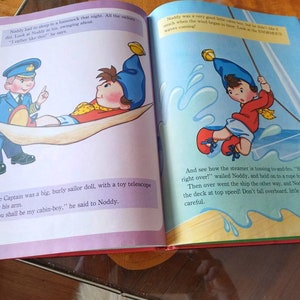 以下が含まれることがあります： 子供向けの本のイラストで、カートゥーンキャラクターのノッティが描かれています。ノッティは赤いシャツを着て、青い帽子をかぶっています。彼は船のロープを掴んでいます。テキストには、「そして、汽船が前後に揺れているのがわかります。 "ひっくり返るぞ！" ノッティは叫び、ロープにしがみついていました。そして、船は反対側に傾き、ノッティは甲板を高速で滑り落ちました！小さなノッティ、海に落ちないで！気を付けて！ 」と書いてあります。