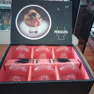 Puede incluir: Una caja negra con interior rojo contiene seis vasos de vidrio transparente. La caja tiene la palabra "REGIS" impresa en la parte delantera. Los vasos est&aacute;n dispuestos en dos filas de tres. La caja est&aacute; abierta y los vasos son visibles.