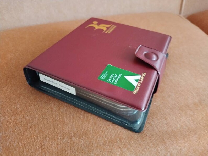 May include: A burgundy leather-bound album with a green sticker that says "Design Council Selection" and "Made in Australia". The album has a label that says "Australian Animals".