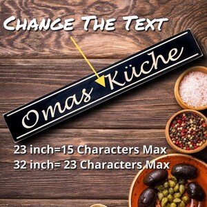 May include: A black and gold wooden sign with the text "Omas K&uuml;che" in gold lettering. The sign is 23 inches long and can hold up to 15 characters. It is also available in a 32-inch size that can hold up to 23 characters.