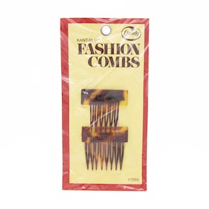 May include: A package of Goody Kant-Slip Fashion Combs. The combs are brown and tortoise shell patterned. The package is red and yellow with the text "Goody Kant-Slip Fashion Combs" printed on it.