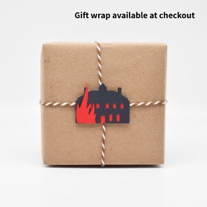 The gift wrap features a tiny paper cutout of Thornfield Manor going up in flames.