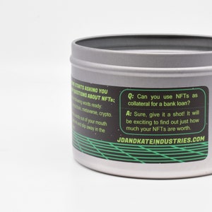 May include: A silver tin with a black and green label that reads "Q: Can you use NFTs as collateral for a bank loan? A: Sure, give it a shot! It will be exciting to find out just how much your NFTs are worth. JDANDKATEINDUSTRIES.COM"