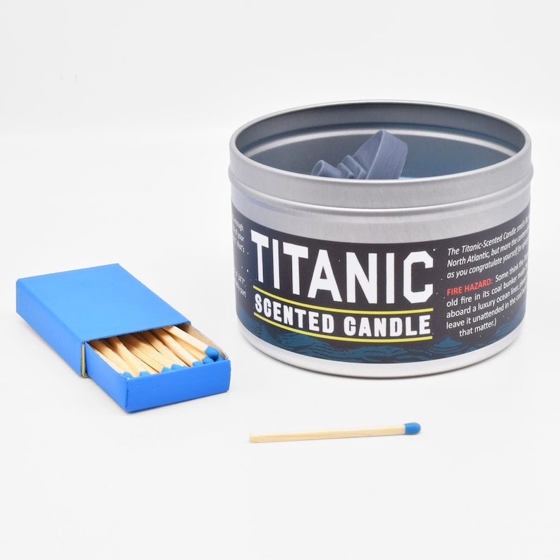 The Titanic Scented Candle sitting next to a matchbox, so you can see that it is significantly larger than a matchbox.