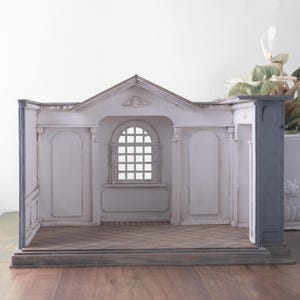 Könnte beinhalten: Eine weiße Keramik-Tasse mit schwarzem Henkel und dem Text "But First, Coffee" in fetter, schwarzer Schrift. Die Tasse steht vor einem verschwommenen Hintergrund. Die Tasse ist etwa 10 cm hoch.