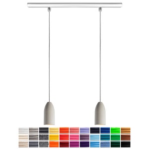 Peut inclure: Un luminaire suspendu moderne avec deux abat-jours blancs en forme de cloche suspendus à une barre argentée. Le luminaire a des cordons réglables et est disponible dans une variété de couleurs.