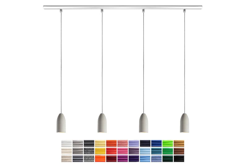 May include: A set of four pendant lights with a silver track and gray fabric shades. The shades are cylindrical and have a slightly rounded top. The lights are hanging from the track by thin wires.