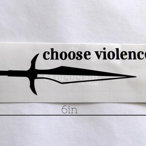 May include: A rectangular sticker with the text "choose violence" above a black sword illustration. The sticker is 6 inches long and 1.8 inches tall. The sticker is on a white background.