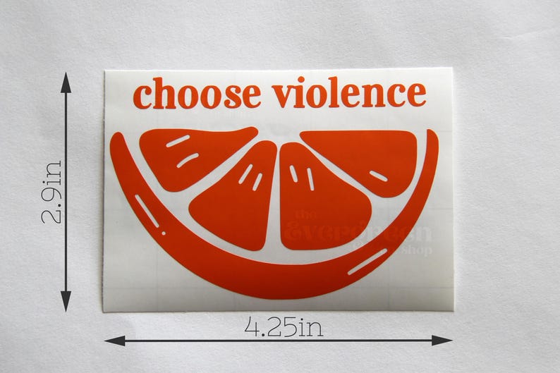 May include: A sticker with the words "choose violence" in red, above a stylized orange slice. The sticker measures 2.9 inches high and 4.25 inches wide.