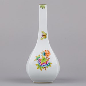 May include: A white porcelain vase with a long, slender neck and a wide, rounded base. The vase is decorated with a colourful floral pattern and a butterfly.