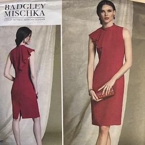 Puede incluir: Un patrón de vestido rojo sin mangas de Badgley Mischka. El vestido presenta un cuello alto, un detalle con volantes en el hombro y un dobladillo hasta la rodilla. El patrón incluye tallas 6-8-10-12-14. El logotipo de Vogue Patterns American Designer es visible.