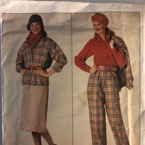 May include: A vintage sewing pattern featuring two women's outfits. The first outfit is a plaid shirt with a brown belt, a beige skirt, and a black hat. The second outfit is a red blouse with a brown belt, plaid pants, and a brown headband. The pattern number is 0995.