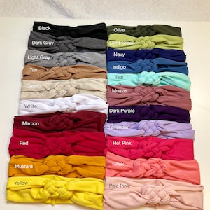 Op de afbeelding: Een set van 18 geknoopte haarbanden in verschillende kleuren, waaronder zwart, donkergrijs, lichtgrijs, bruin, cr&egrave;me, wit, donkerrood, rood, mosterd, geel, olijf, lichtgroen, marineblauw, indigo, turquoise, mauve, donkerpaars, lavendel, roze, roze en lichtroze.