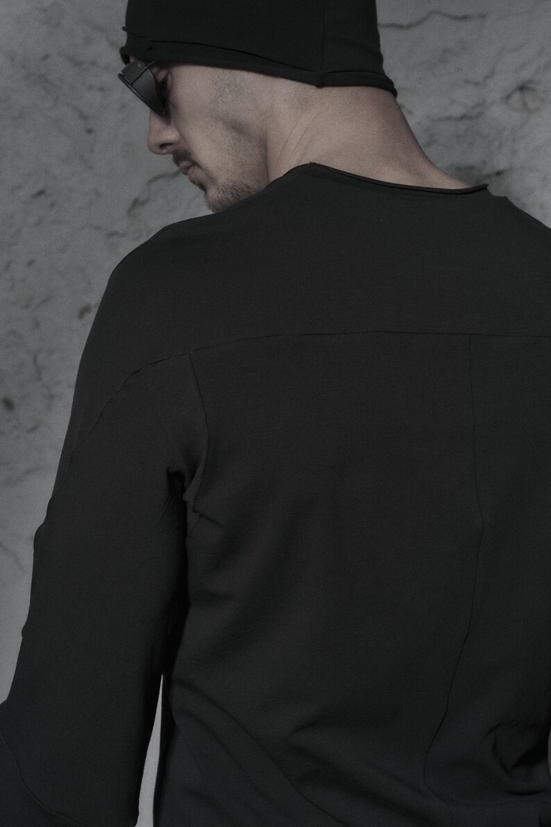 May include: A black long-sleeved shirt with a crew neck and a seam down the back.