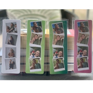 May include: Set of four bookmarks featuring different photos of a couple and their child. The bookmarks are printed on cardstock and have a white border. The bookmarks are in a variety of colors, including green, pink, and blue.