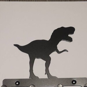 Op de afbeelding: Een zwarte metalen dinosaurus silhouet wandhaak met vijf haken.