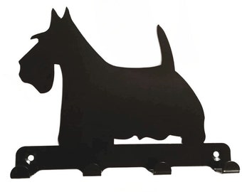 May include: Black metal silhouette of a Scottish Terrier dog with three hooks on the bottom for hanging keys or other items.