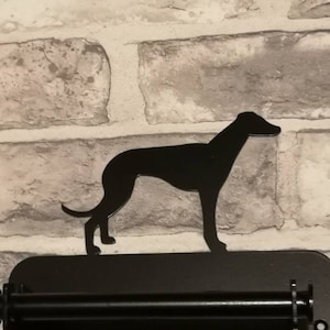May include: Black metal kitchen paper towel holder with a silhouette of a greyhound dog on top.