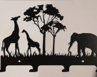 May include: Black metal key holder featuring a silhouette of a giraffe, a baby giraffe, an elephant, and a tree. The key holder has three hooks.