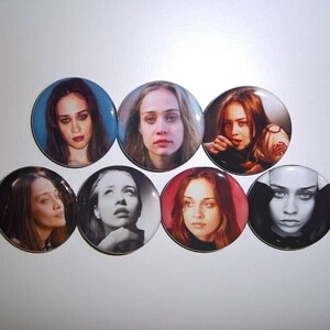 Peut inclure: Un ensemble de sept boutons ronds pr&eacute;sentant des portraits d'une femme. Les boutons affichent diverses images en couleur et en noir et blanc, avec diff&eacute;rentes expressions et poses. Les boutons sont dispos&eacute;s sur une surface blanche.