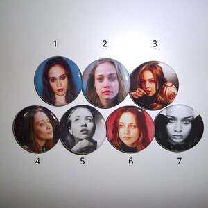 Peut inclure: Sept badges ronds repr&eacute;sentant des portraits d'une femme. Les badges pr&eacute;sentent diff&eacute;rentes images de la m&ecirc;me femme, avec des variations de couleur et de style. Les badges sont dispos&eacute;s en cercle.