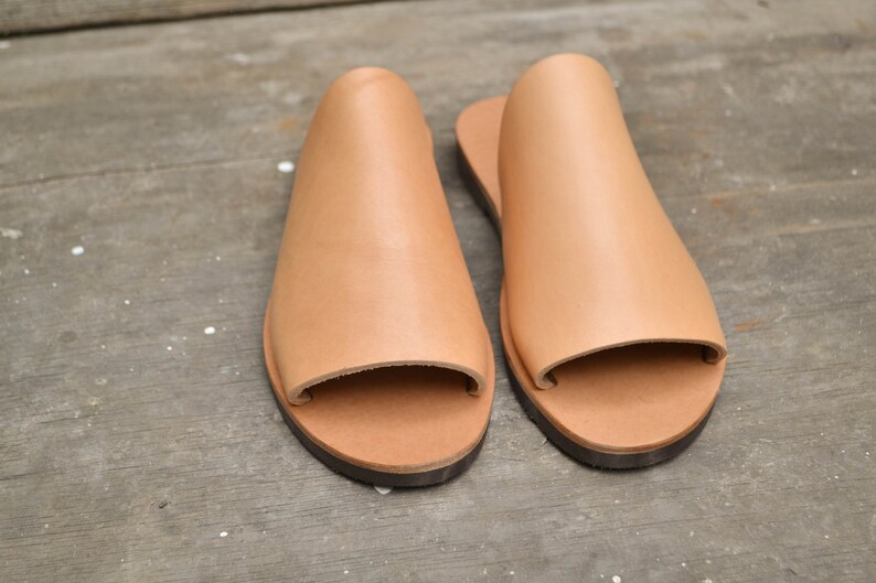 May include: A pair of tan leather open-toe sandals with a simple design.