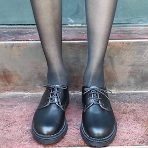 May include: A pair of black leather lace-up shoes with a rounded toe and a thick sole.