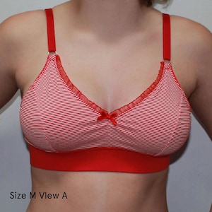Puede incluir: Sujetador a rayas rojas y blancas con tirantes y banda rojos. El sujetador tiene un peque&ntilde;o lazo rojo en el centro y un delicado ribete en el borde superior. El texto "Size M View A" es visible en la parte inferior.