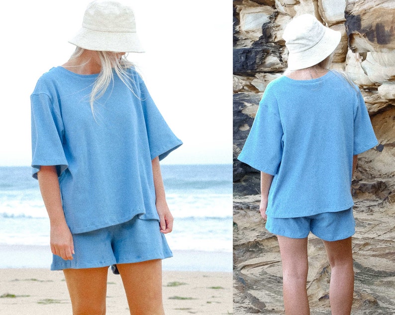 May include: A light blue cotton short set with a relaxed fit. The top has a round neckline and short sleeves. The shorts have a high waist and a relaxed fit.