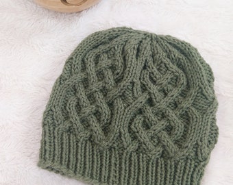 May include: A green knitted hat with a cable knit pattern.
