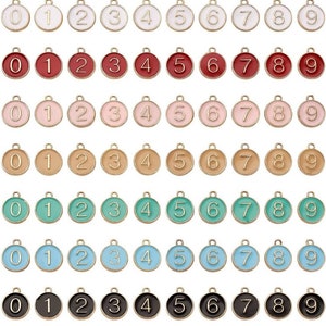 May include: Set of ten gold-tone metal charms with enamel numbers 0-9. The charms are round and have a loop at the top for attaching to a necklace, bracelet, or other jewelry.