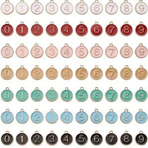 May include: Set of ten gold-tone metal charms with enamel numbers 0-9. The charms are round and have a loop at the top for attaching to a necklace, bracelet, or other jewelry.