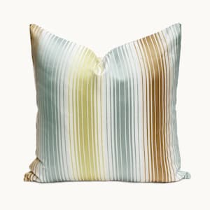 May include: A striped throw pillow with blue, yellow, and brown stripes on a white background.
