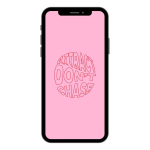 May include: A pink smartphone screen with the text "ATTRACT DON'T CHASE" in a red circle.