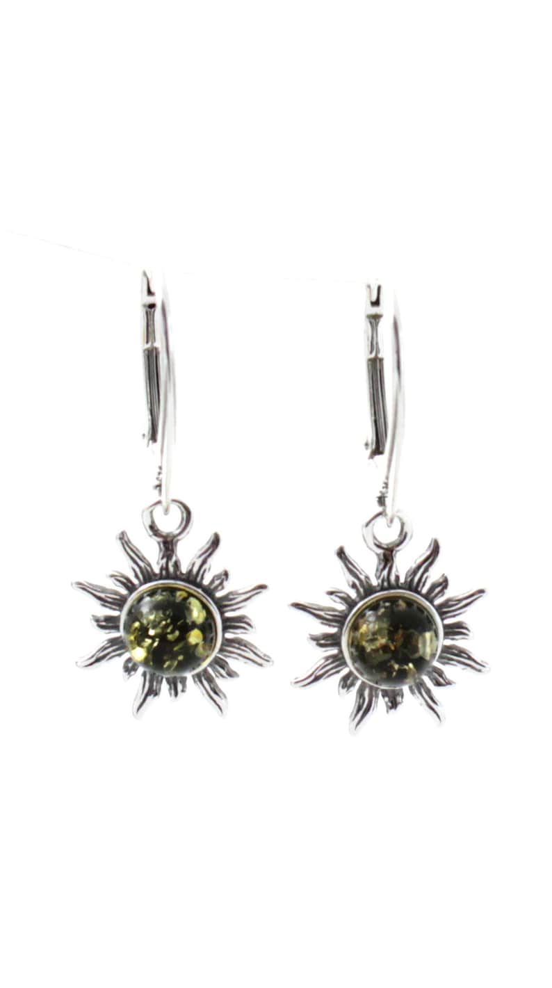 May include: A pair of silver earrings with green amber stones set in a sunburst design. The earrings have leverback closures.