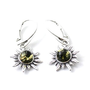 May include: A pair of silver dangle earrings with a green amber stone set in a sunburst design.