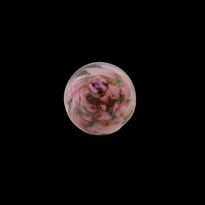 May include: A spherical glass marble featuring a translucent light pink base with swirling white patterns and embedded flecks of metallic copper glitter throughout the interior, creating a textured appearance within the smooth, polished glass surface.