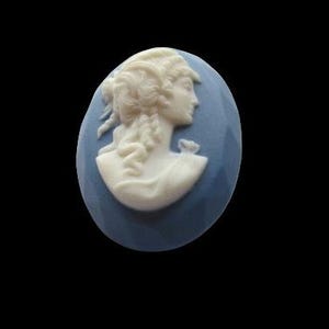 May include: A blue cameo with a white porcelain carving of a woman's profile.