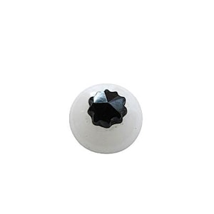 May include: A white glass ball with a black star-shaped embellishment.