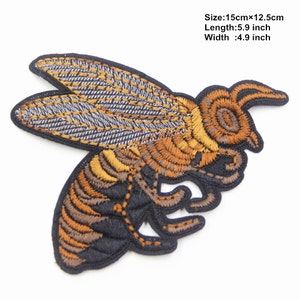 May include: Embroidered bee patch with brown, yellow, and black details. The patch is 5.9 inches long and 4.9 inches wide.
