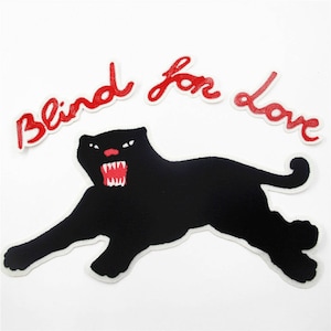 Puede incluir: Silueta de pantera negra con texto bordado en rojo "Blind for love" sobre un fondo blanco.