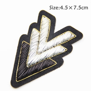 May include: Black and silver embroidered arrow patch with a gold outline. Size: 4.5 x 7.5 cm.
