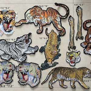 May include: Ten embroidered iron-on patches featuring tiger designs in various colors and sizes. The patches range in size from 6.8 inches by 7.2 inches to 14.5 inches by 9 inches.