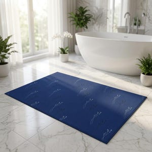 Peut inclure: Un tapis de bain rectangulaire de couleur bleu marine profond présentant un motif répétitif de fines lignes blanches représentant de petites tiges et fleurs délicates, disposées en grille sur toute la surface du tissu.
