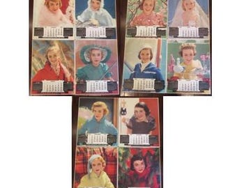 May include: A set of eight vintage calendar cards featuring images of young women in various poses and settings. Each card has a calendar grid with the months of the year.
