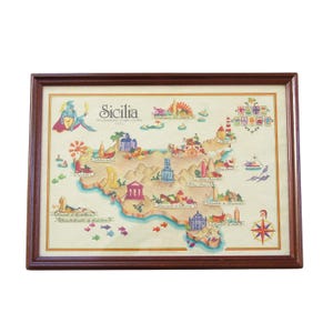 May include: Framed map of Sicily with a brown wooden frame. The map is illustrated with colorful drawings of landmarks, boats, and figures. The word "Sicilia" is at the top, and the map is in a rectangular shape.