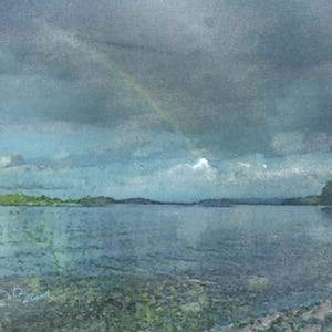 May include: Watercolor painting of a serene lake scene under a cloudy sky. A faint rainbow arcs across the sky, with green hills and distant mountains. The water reflects the sky's colors, creating a tranquil landscape.
