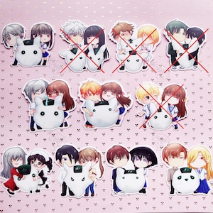 May include: A collection of die-cut stickers featuring various anime-style characters holding white rice ball mascots. Some stickers are marked with a red X. The characters have diverse hair colors and school uniforms, arranged in a grid on a pink background.